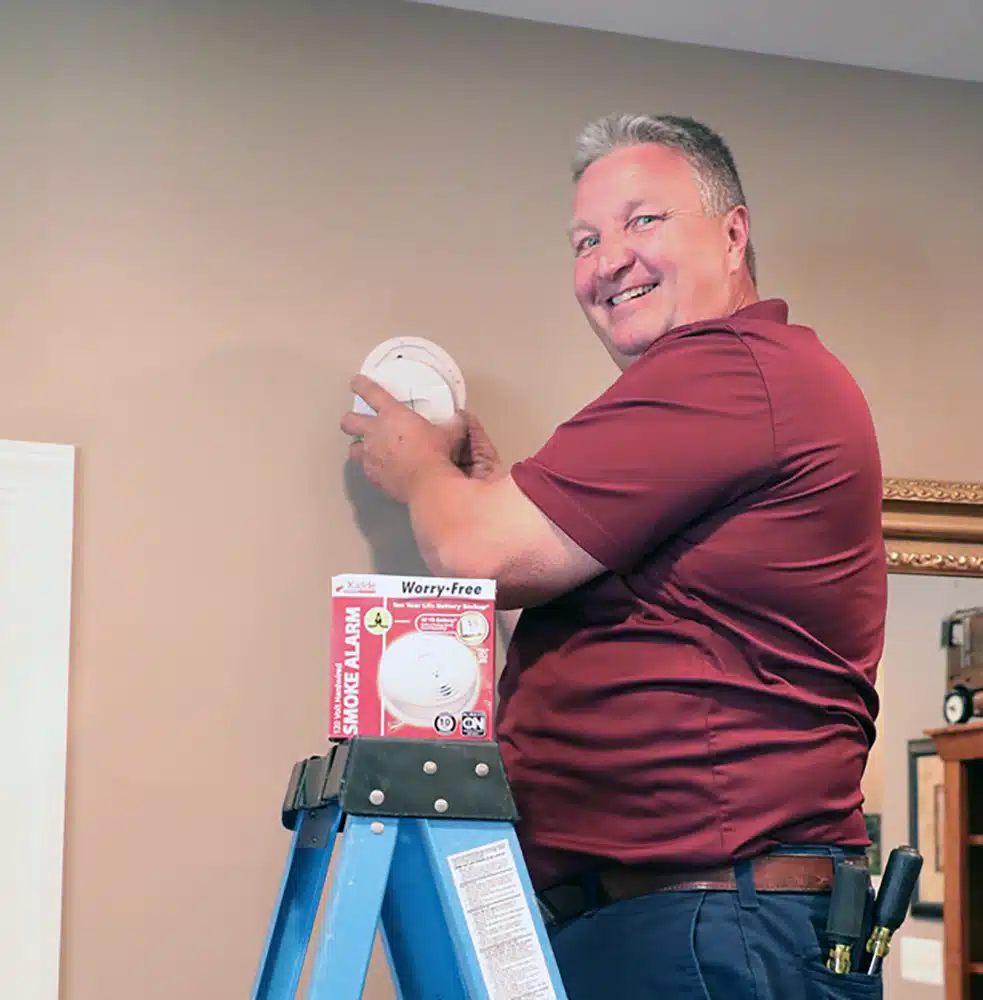 Electrician installing smoke detectors in residential home in Warrenton, VA.
