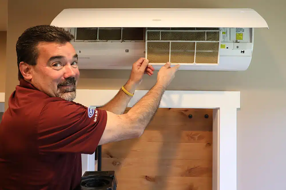 Appleton Campbell electrician holding dirty minisplit filter in residential home in Warrenton, VA.